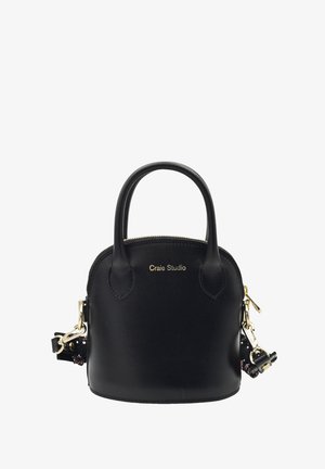 Sac à main en cuir noir avec deux poignées courtes, quincaillerie dorée, fermeture éclair et une bandoulière amovible arborant un accent à motifs.