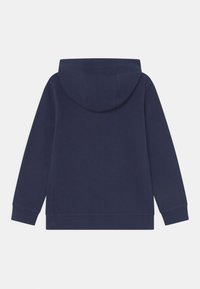 Sudadera color azul marino con mangas largas, puños acanalados y capucha, vista desde la parte trasera sobre un fondo blanco.