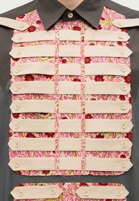 Γκρι πουκάμισο με ροζ πάνελ με λουλούδια, διακοσμημένο με οριζόντιες λωρίδες κρεμ ύφασμα που στερεώνονται με κουμπιά.