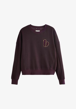 Burgundowa bluza z fakturowanym, wafelkiem; posiada okrągły dekolt oraz haftowane logo 'b' w kolorze złotym na lewej piersi.