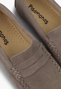 Brązowe zamszowe loafersy z teksturowaną cholewką, detalami w postaci szwów oraz gładką skórzaną wkładką. Logo widoczne na wkładce.
