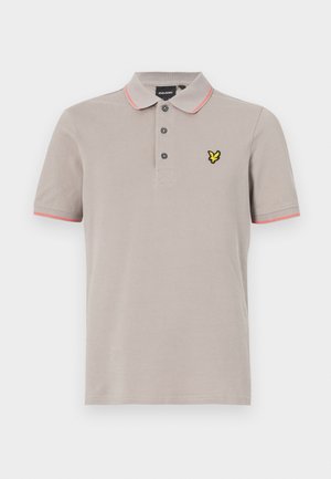Polo shirt gris clair avec col, trois boutons et accents roses au niveau des manches. Présente un logo jaune sur la poitrine. Matière en coton.