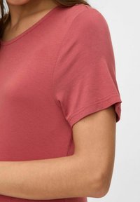 T-shirt rosa polveroso con scollatura tonda e maniche corte, realizzato in morbido cotone, con una texture liscia e dettagli di cucitura minimi.