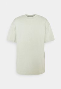 T-shirt en coton vert clair avec col rond, manches courtes et coupe décontractée. Texture lisse avec fentes latérales à l'ourlet pour plus de liberté de mouvement.