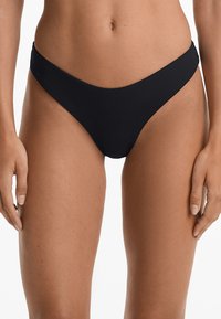 Černé bikiny s ribovanou texturou, nízkým střihem a minimálním zakrytím zad, s hladkým pasem a čistými liniemi.