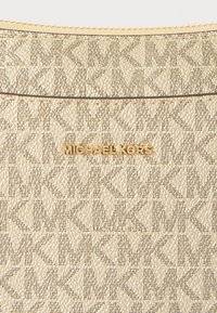 Pochette Michael Kors tono oro con motivo monogram. Superficie текстurizzata con un effetto metallico; chiusura con zip sulla parte superiore.