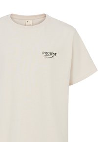 Krem t-shirt od pamuka s okruglim izrezom i kratkim rukavima. "PROTEST" logotip otisnut na lijevoj strani prsnog dijela u tamnozelenoj boji.