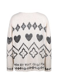 Strickpullover in Creme mit dunkelgrauem Herz und floralen Mustern. Verfügt über einen weiten Ausschnitt, lange Ärmel und eine weiche Textur. Text am Saum.