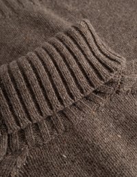 Καφέ πλεκτή ζακέτα με ραβδωτό γιακά και υφασμάτινη υφή, με χρωματιστές πιτσιλιές σε όλη την επιφάνεια για επιπλέον λεπτομέρεια.