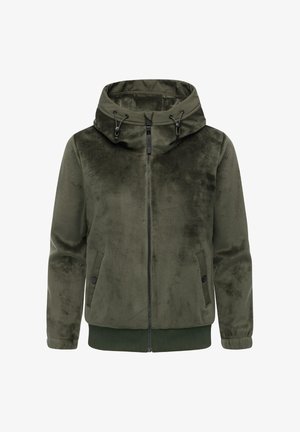 Oliivivihreä corduroy-takki, jossa on vetoketjukiinnitys, säädettävä huppu ja ribbauslahkeiden hihnat. Sujuva pinta, sivutaskut ja minimaalinen yksityiskohtaisuus.