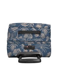 Maleta con ruedas, de tela azul con estampado de hojas tropicales beige. Cuenta con un asa retráctil y cerradura con hardware compatible con TSA.