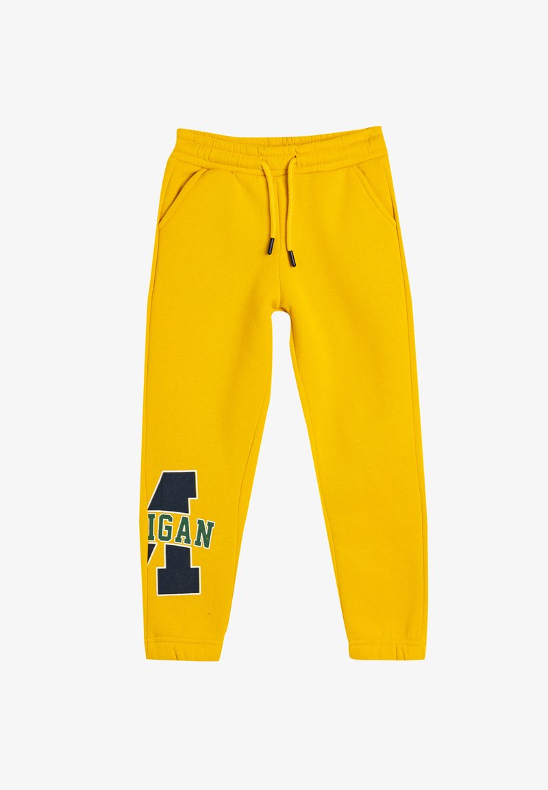 Gule sweatpants med elastisk talje, snøre, to sidelommer og et sort og grønt logo-design på venstre lår.