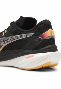 Čierna bežeck�á obuv s prekrytím z látky, jasnými akcentmi a gumovou podrážkou. Obsahuje logo Puma, polstrovaný opätok a branding NITRO na medzipodrážke.