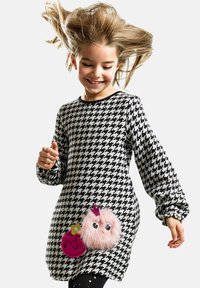 Vestito in motivo houndstooth bianco e nero, caratterizzato da un'imbottitura rosa soffice con occhi e una corona, e un accento rotondo rosa.