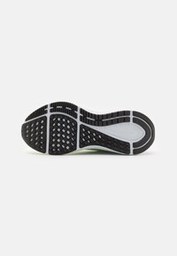 Semelle de chaussure en caoutchouc noir avec motif de grip texturé, dotée d'accents blancs et verts et d'un design segmenté pour plus de flexibilité.