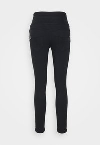 Leggings negros con una cintura alta, que cuentan con dos bolsillos traseros con detalles bordados y pequeños acentos plateados. Tela suave y elástica.
