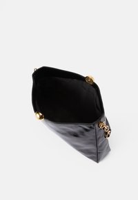 Schwarze Lederhandtasche mit glatter Textur, ausgestattet mit einem goldenen Hardware-Verschluss und einem geräumigen Innenraum. Offenes Design für einfachen Zugriff.