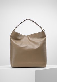 Bolso hobo de suave cuero topo con parte superior curva y un asa de cuero marrón. Presenta una textura sutil y un diseño minimalista.