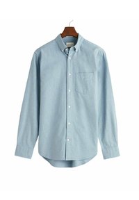Camisa de algodón azul claro con botones y mangas largas, bolsillo en el pecho y dobladillo curvado. Presenta un cuello clásico y una tapeta de botones blanca.