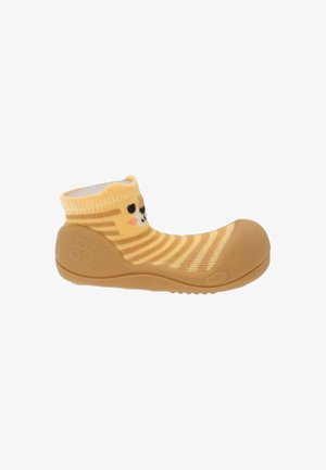 Scarpa morbida per bambino con suola in gomma e parte superiore a calza a righe gialle con un volto di gatto sorridente sul polsino della caviglia.