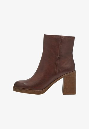 Bottine en cuir marron avec un bout arrondi, un talon en bois empilés, des coutures minimales et une texture lisse.
