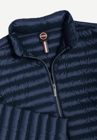 Mørkeblå quiltet jakke med stående krave, lynlås foran og Colmar Originals-mærke inde i kraven.