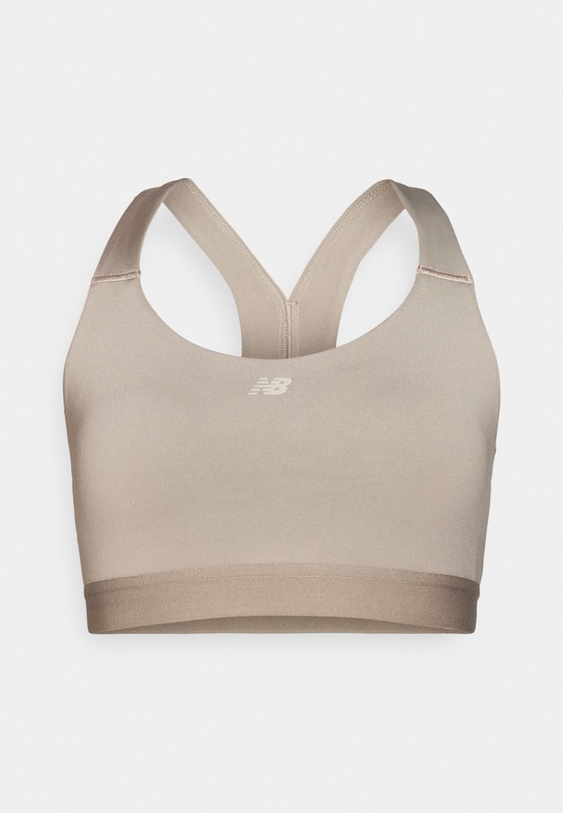 Beige sportbehå med en slät tygkvalitet, racerback-design och ett elastiskt band i botten. Har en diskret logga framtill.