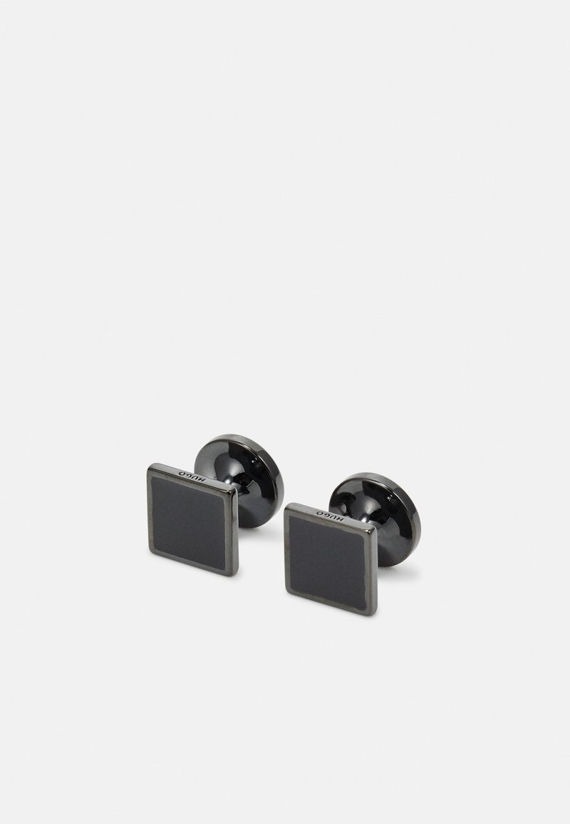 Fyrkantiga manschettknappar med en elegant svart emalj yta, inramad i glänsande silverfärgad metall. Rundade baksidor för säker fastsättning.