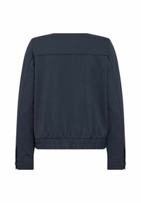 Marineblauwe jas van een gladde stof, met een elastische tailleband en lange mouwen. Heeft een recht model en een minimalistisch ontwerp zonder zichtbare logo's.