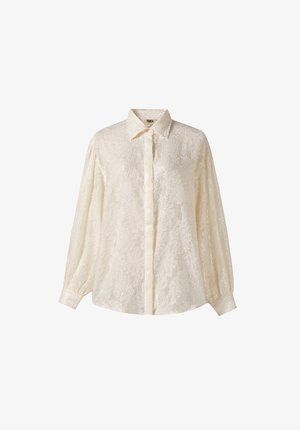 Blouse ivoire à manches longues avec un motif floral texturé, boutonnée sur le devant et coupe décontractée. Comprend un col classique et des poignets élastiqués.