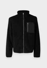 Schwarze Fleecejacke mit hohem Kragen, durchgehendem Reißverschluss und einer Reißverschlusstasche auf der Brust. Strukturierter Stoff, lange Ärmel und eine lockere Passform.