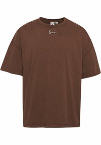 Brown cotton t-shirt with short sleeves, round neckline, and white embroidered logo on the chest, featuring a relaxed fit and smooth texture.