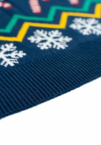 Maglione blu lavorato a maglia con motivi bianchi a fiocco di neve, righe a zigzag gialle e verdi, e orlo a costine. Texture morbida e design accogliente.