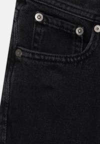 Schwarze Denim-Jeans mit klassischem Design, silbernen Komponenten und einem detailreichen Fronttaschenbereich mit sichtbaren Nähten und strukturiertem Stoff.