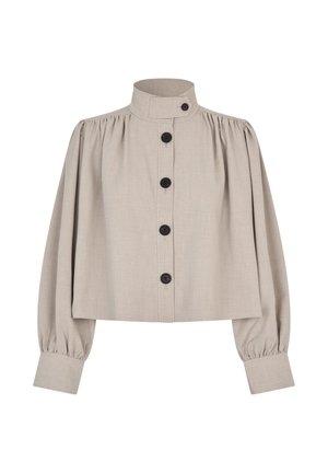 Veste courte beige avec un col montant, des manches bouffantes et des boutons noirs sur le devant. Réalisée dans un tissu texturé.