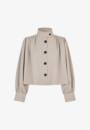 Veste courte beige avec un col montant, des manches bouffantes et des boutons noirs sur le devant. Réalisée dans un tissu texturé.