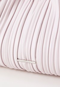 Lys rosa lær clutch med folderstruktur og et logo i sølvfarge. Clutchen har en myk, jevn overflate og et elegant design.
