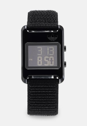 Digital ur med en sort rektangulær urskive, digital skærm der viser tiden i hvid, og et struktureret sort strop i stof. Adidas-logoet øverst.