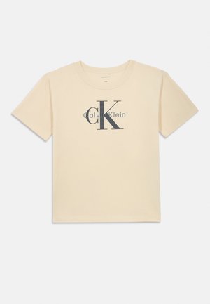 Kortærmet creme bomulds t-shirt med et stort gråt "CK" logo og teksten "Calvin Klein" nedenfor. Klassisk crew neck design.