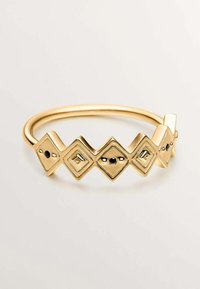 Pulsera de tono dorado con un diseño de zigzag y eslabones en forma de diamante. Cada eslabón tiene una piedra decorativa negra en el centro. Acabado suave y pulido.