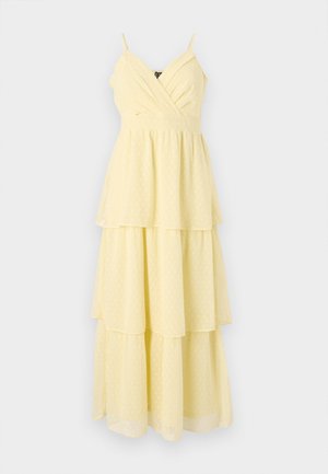 Abito midi giallo a strati con spalline sottili, scollatura a V e pois testurizzati. Presenta un corpetto aderente e una gonna a strati svolazzante.