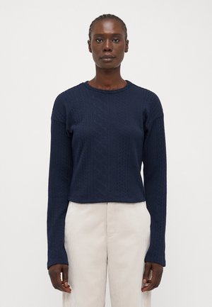 Navy blue knitted sweater with a textured pattern, round neckline, and long sleeves. The fit is slightly cropped at the waist.