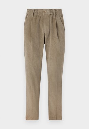 Pantaloni din catifea la culoarea maro deschis, cu un brâu elastic, pliseuri în față și picioare tapered. Textură moale cu nervuri verticale.