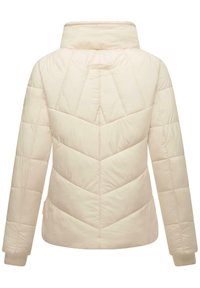 Veste rembourrée beige clair avec piqûres en chevrons, col montant et poignet côtelé. Texture lisse, silhouette droite et minimalisme dans le branding.