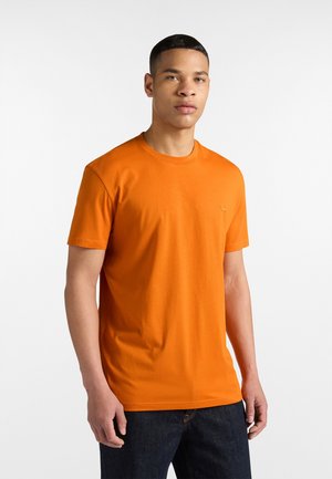 Orange Baumwoll-T-Shirt mit kurzen Ärmeln und Rundhalsausschnitt, mit einem kleinen, dezenten Logo auf der Brust und glatter, gleichmäßiger Textur.