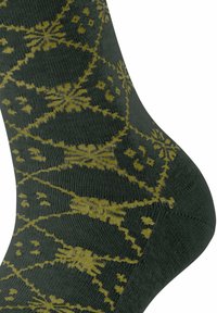 Grüne Socken mit einem gelben geometrischen Muster. Die Textur ist gerippt, mit einer enganliegenden Form um den Knöchel.