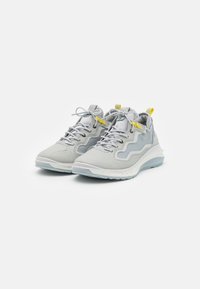 Gray athletic shoes with textured fabric, mesh panels, and a white sole, featuring yellow accents and a lace-up design.