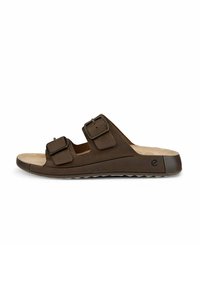 Brun glidsandal med två justerbara remmar, mjuk fotbädd och texturerad gummisula, med rund tå och minimalistisk design.