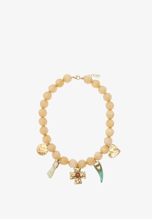 Naszyjnik z koralików z kremowymi, fasetowanymi koralikami oraz złotymi charmsami, w tym krzyżem, sercem oraz zielonym rogiem.