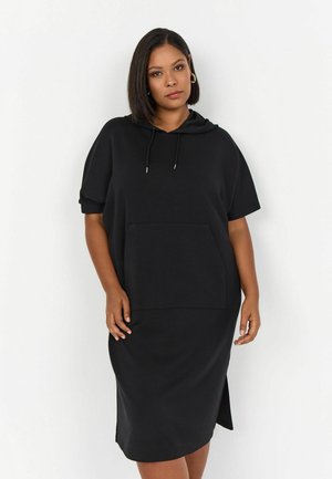 Robe hoodie noire en tissu doux, dotée de manches courtes, d'une poche avant et d'incisions sur les côtés pour plus de mouvement et de confort.